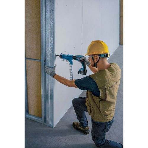 Ein Bauarbeiter mit gelbem Helm benutzt eine blaue Schraubpistole an einer Wandplatte.