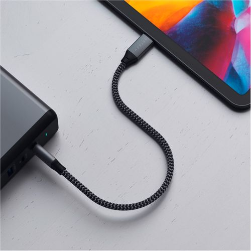 Un cavo di ricarica grigio collega un tablet a un power bank.