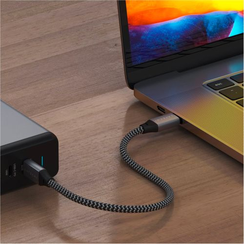 Un cavo USB-C grigio collega un power bank a un laptop.