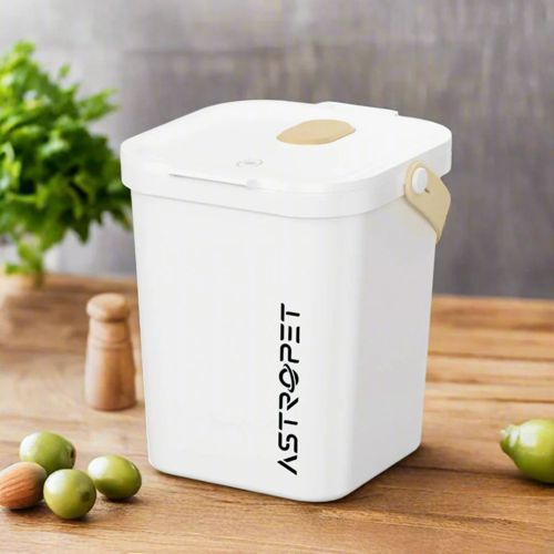 Bidone bianco Astropet su tavolo di legno con olive e verde.