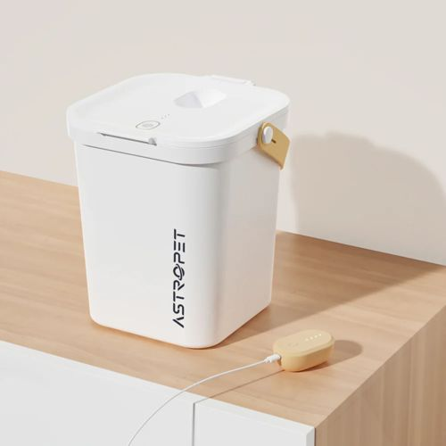 Un distributore automatico bianco per animali con finiture gialle e un caricatore.
