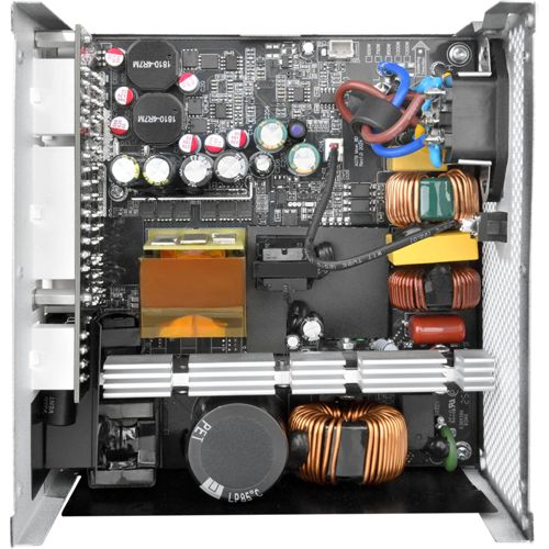Binnenaanzicht van een computer voedingseenheid, met printplaten, condensatoren, transformatoren en draden.