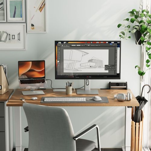 Una scrivania con laptop, monitor, tastiera e mouse. Pianta appesa sullo sfondo.