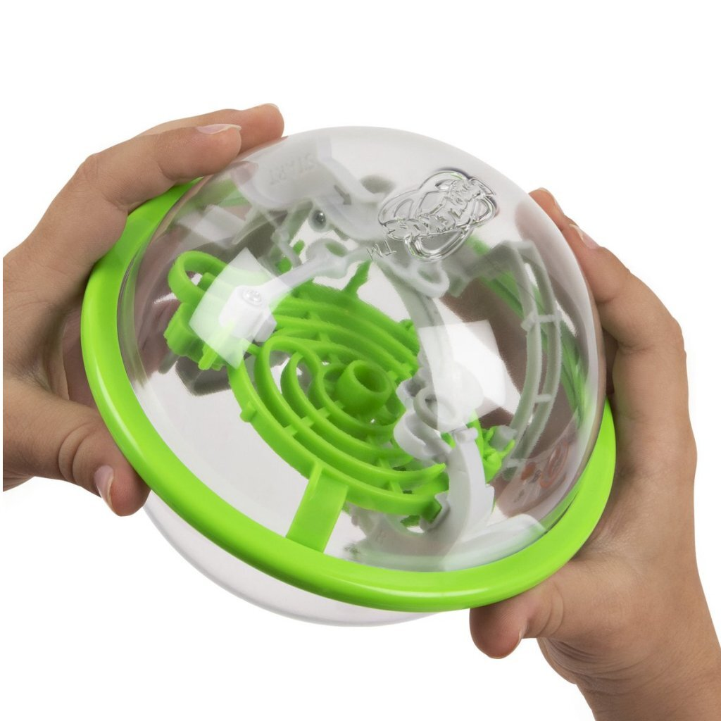 Dos manos sostienen una pelota transparente con borde verde y un laberinto dentro.