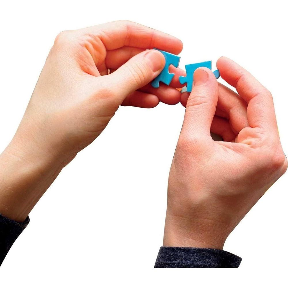 Dos manos unen dos piezas de rompecabezas azules.