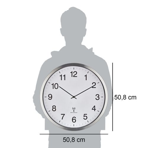 Eine Person hält eine weiße Wanduhr mit silbernem Rahmen und schwarzen Zeigern.