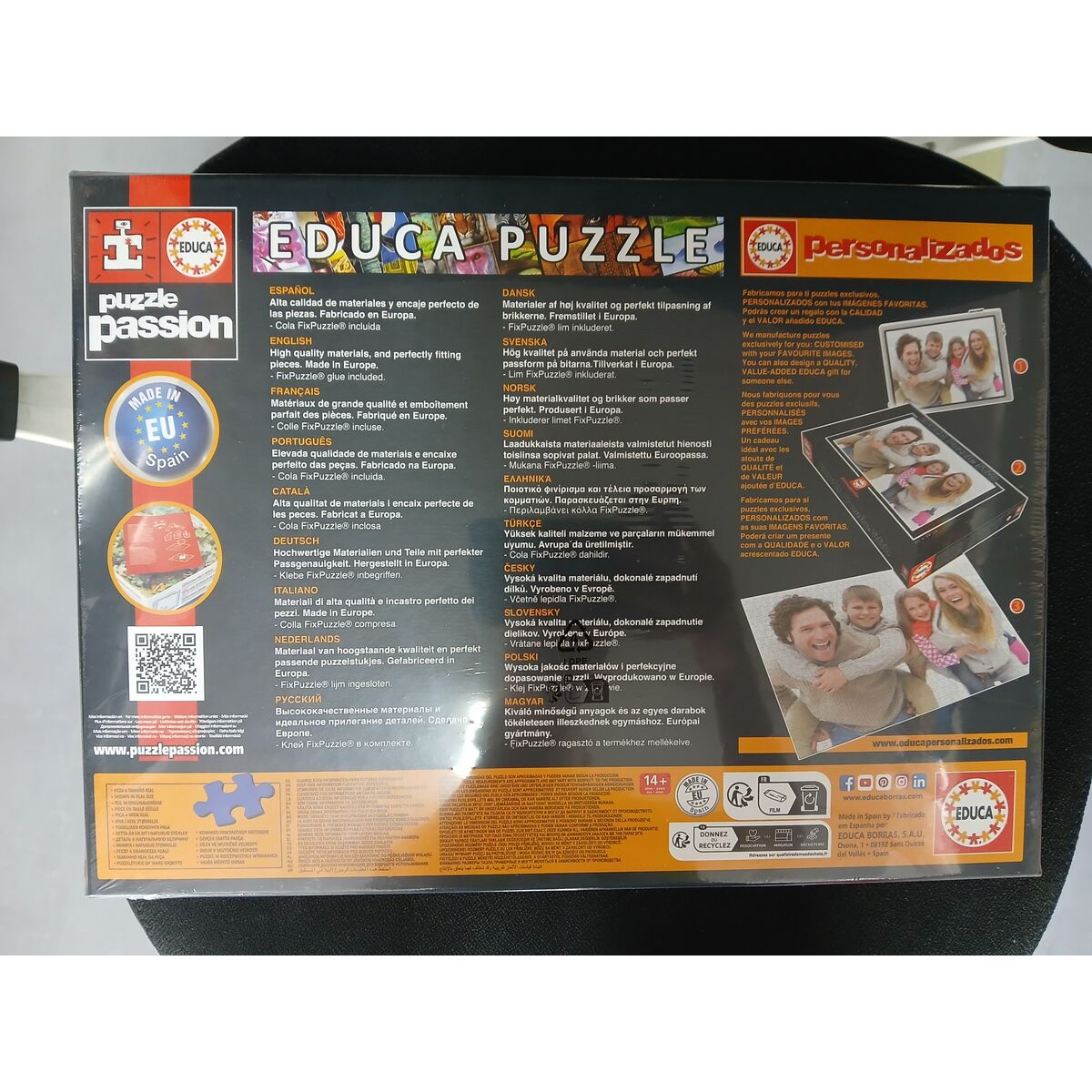 Confezione di un puzzle Educa con testo multilingue e immagini di famiglie.