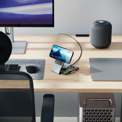 Scrivania con monitor, telefono, orologio, altoparlante, laptop e tower.