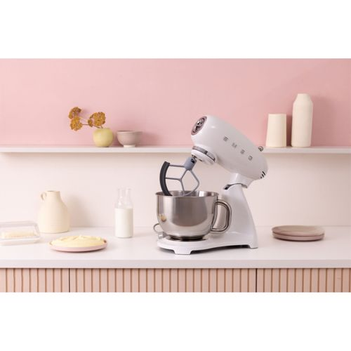 Ein weißer Standmixer mit Edelstahlschüssel auf einer Arbeitsplatte.