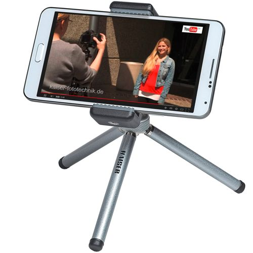 Ein Smartphone auf einem kleinen Stativ zeigt ein Video mit zwei Frauen und dem YouTube-Logo.