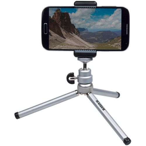 Ein kleines Silberstativ hält ein Smartphone, das eine Berglandschaft zeigt.