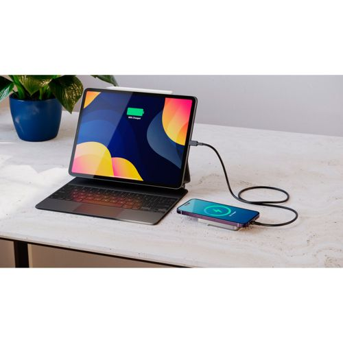 Ein Tablet mit Tastatur und ein aufgeladenes Smartphone liegen auf einem Tisch.