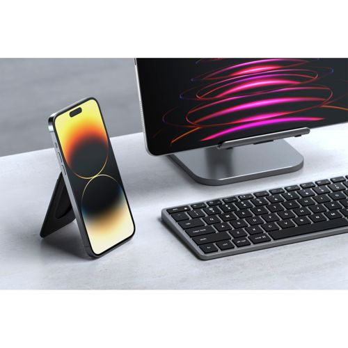Uno smartphone è su un supporto accanto a una tastiera e un monitor con linee colorate.