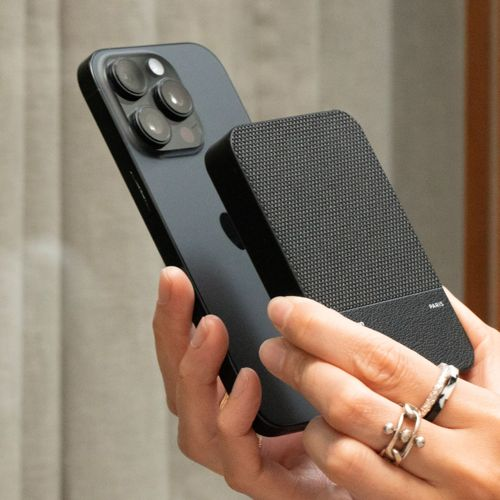 Une main tient un smartphone sombre, une autre main tient une banque d'alimentation noire.