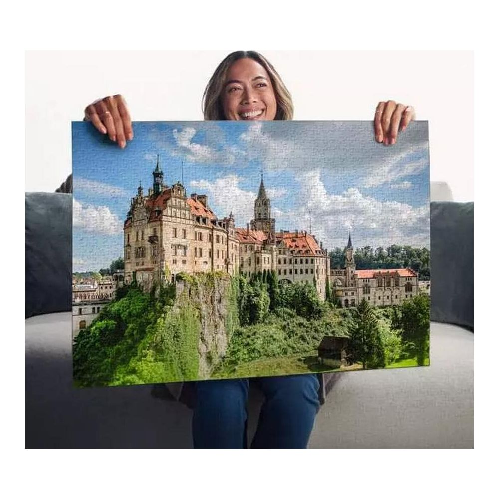 Una donna tiene un puzzle di un castello su una collina.
