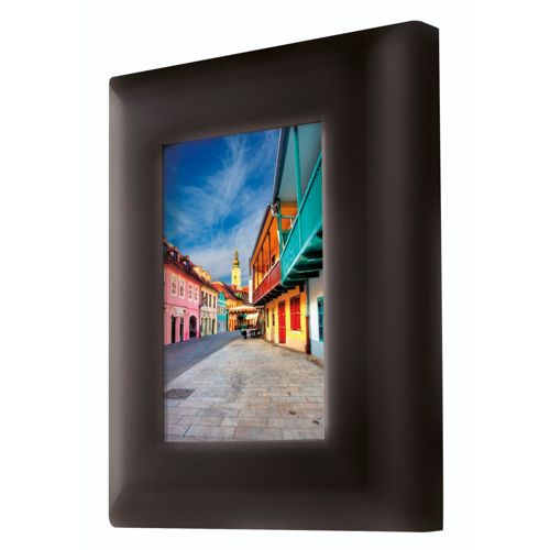 Un marco oscuro muestra una escena callejera con edificios coloridos y un campanario.