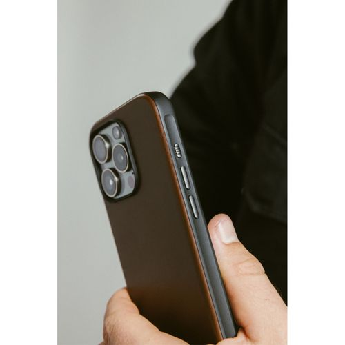 Eine Hand hält ein braunes Handy mit drei Kameras. Seitentasten sind sichtbar.