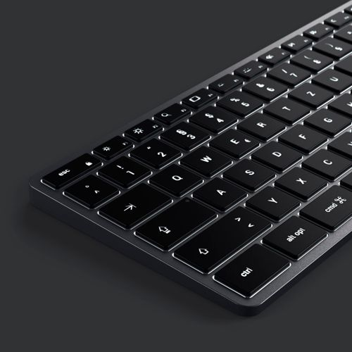 Eine Nahaufnahme einer beleuchteten schwarzen Tastatur auf dunklem Hintergrund.