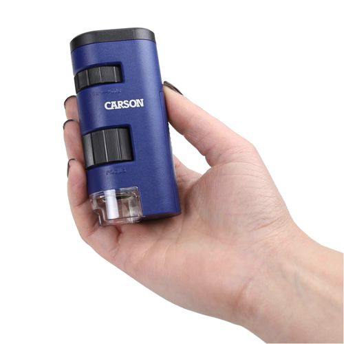 Una mano tiene un microscopio Carson blu con rotelle di messa a fuoco e una lente.