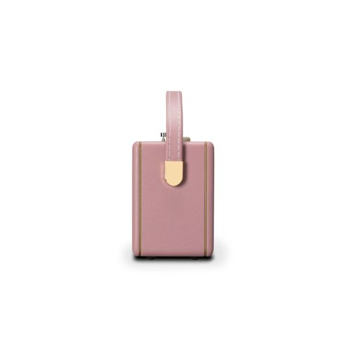 Una borsa rettangolare rosa con finiture dorate e un manico, vista di lato.