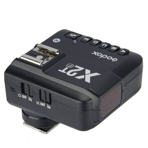 Un trigger flash Godox X2T nero con pulsanti e interruttori su sfondo bianco.