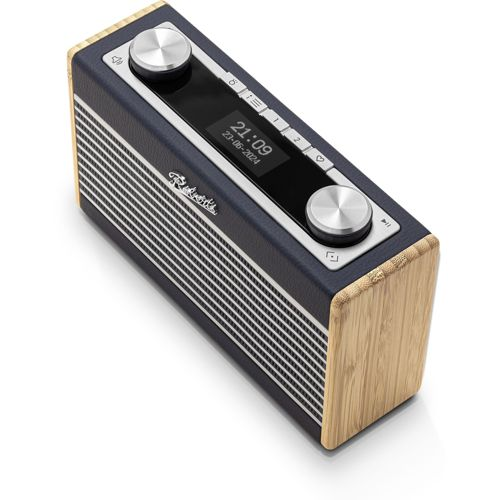 Une radio rectangulaire sombre avec des accents en bois et des boutons argentés. L'écran affiche 21:09.