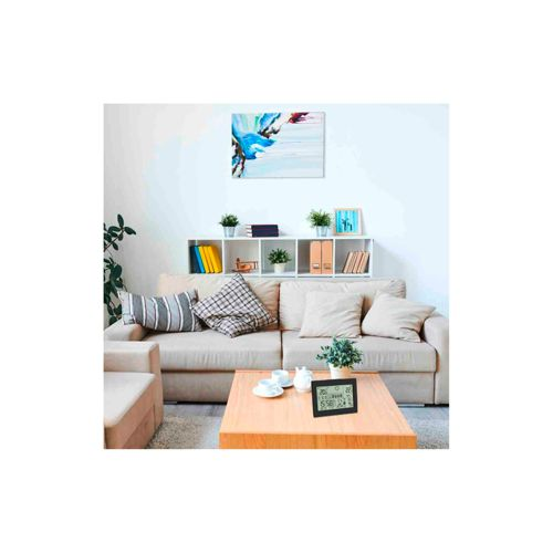 Ein Wohnzimmer mit Sofa, Couchtisch und einem digitalen Thermometer.