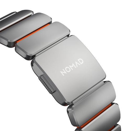 Ein graues Armband mit orangefarbenen Akzenten und dem NOMAD-Logo.