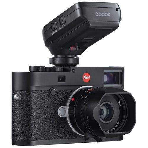 Una fotocamera Leica nera con un'unità flash Godox montata sul mirino.