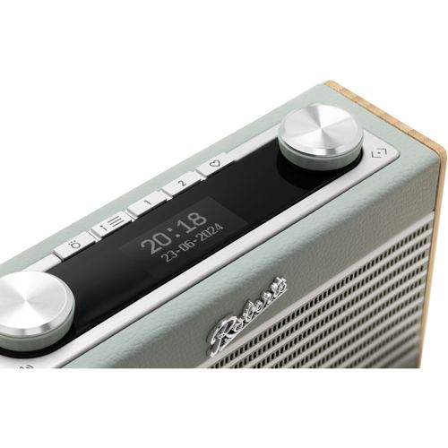 Une radio vert clair avec des boutons argentés et un écran numérique affichant l'heure et la date.