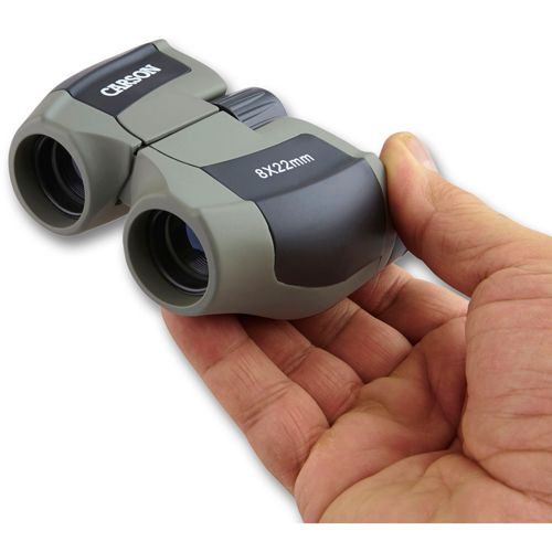 Binocolo grigio Carson 8x22mm tenuto in mano.