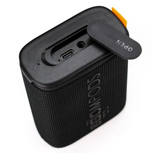 Haut-parleur noir avec port USB-C et couvercle ouvert.