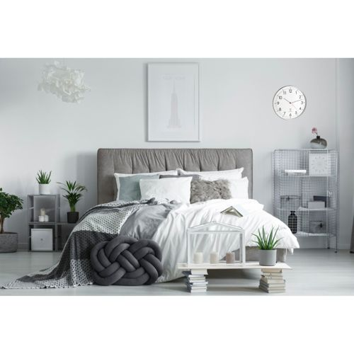 Ein modernes Schlafzimmer mit einem großen Bett, Kissen und einer Decke.