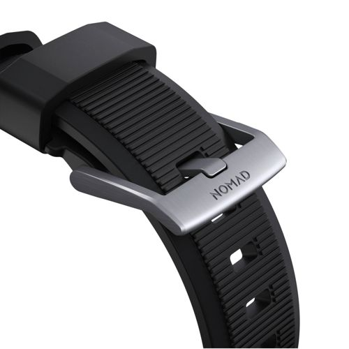 Primer plano de una correa de reloj negra con hebilla plateada, muestra la palabra NOMAD.