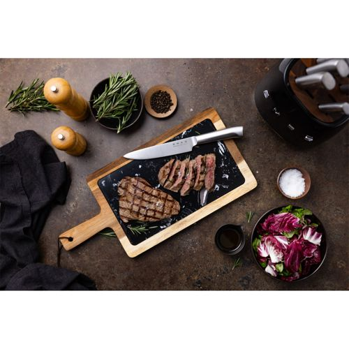 Gegrillte Steaks auf einem Brett mit Rosmarin, Pfeffer, Salz und Salat.