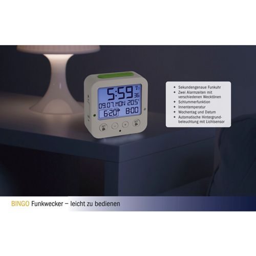 Ein weißer Digitalwecker zeigt 5:59 an und steht auf einem Nachttisch.