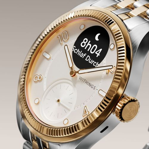 Primo piano di uno smartwatch argento e oro con quadrante bianco.