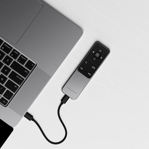 Un laptop grigio e un telecomando nero collegati da un cavo.