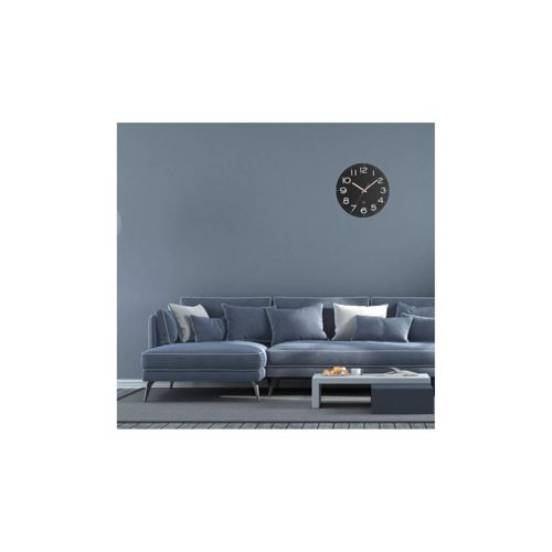 Ein blauer Ecksofa mit Kissen und einem Couchtisch vor einer blauen Wand mit einer Uhr.