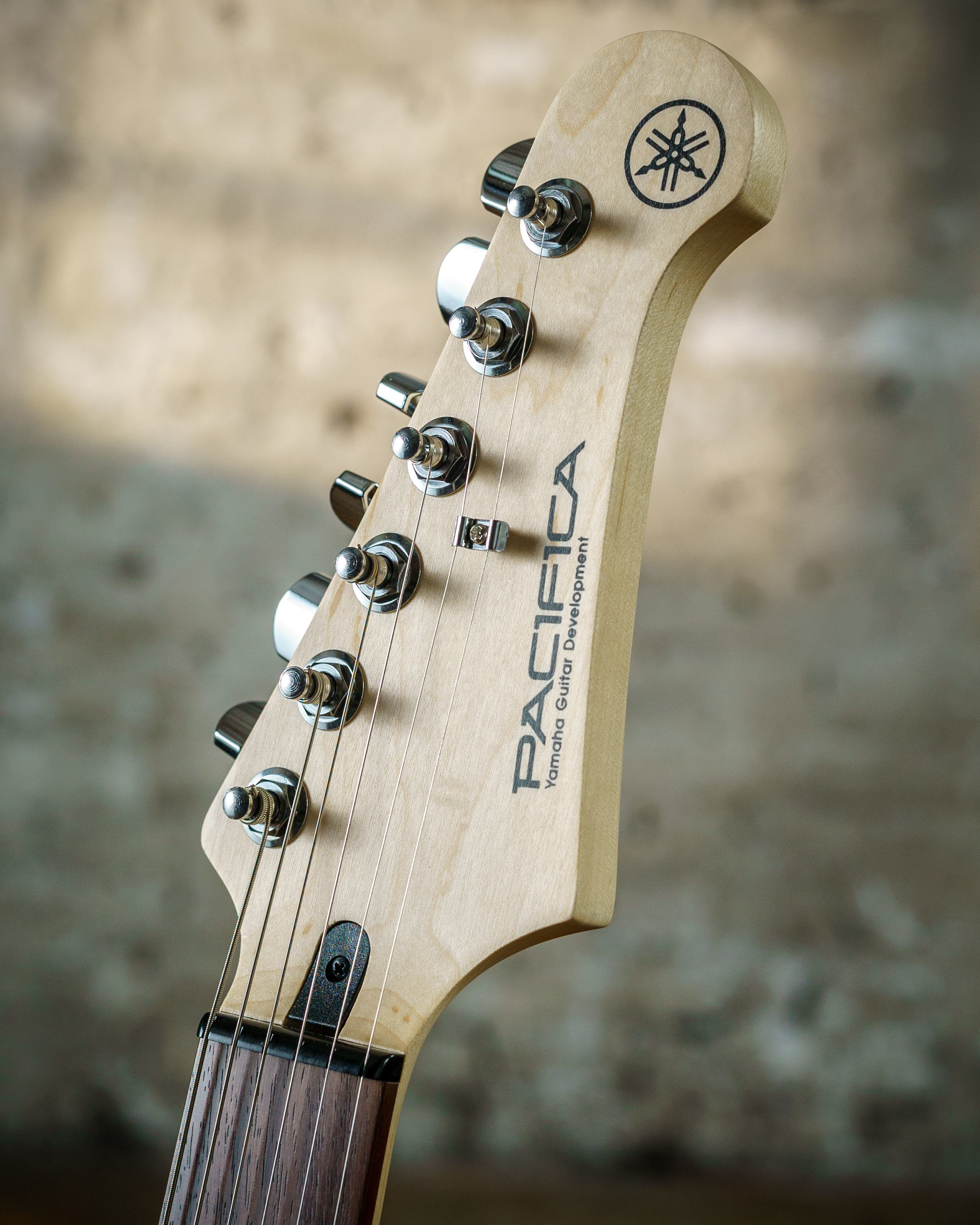 Nahaufnahme des Kopfes einer Yamaha Pacifica Gitarre mit Stimmmechaniken und Logo.