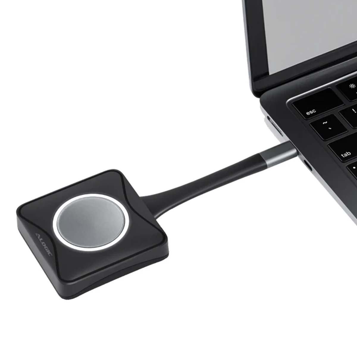 Ein schwarzer Alogic-Adapter mit silbernem Knopf ist an einen Laptop angeschlossen.