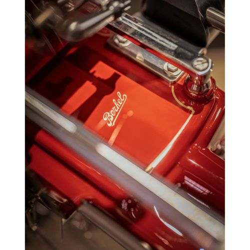 Eine rote Berkel-Schneidemaschine mit Chromdetails und dem Logo.