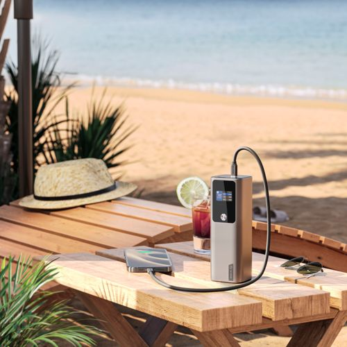Un caricabatterie e un telefono sono su un tavolo in spiaggia.