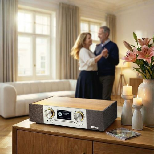 Paar tanzt im Wohnzimmer, Stereoanlage und Blumen im Vordergrund.