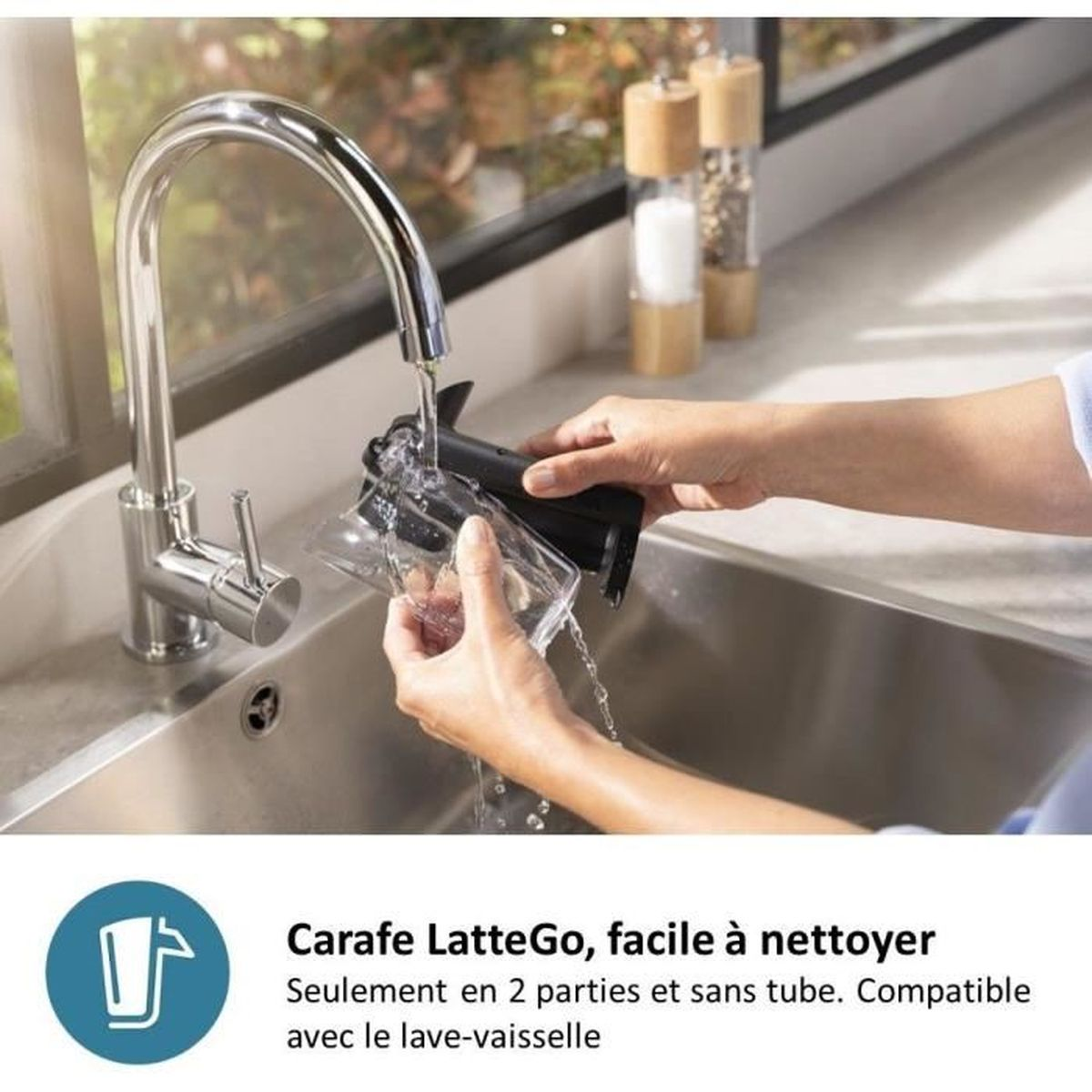 Hände spülen eine Kaffeekaraffe unter fließendem Wasser in einer Spüle.