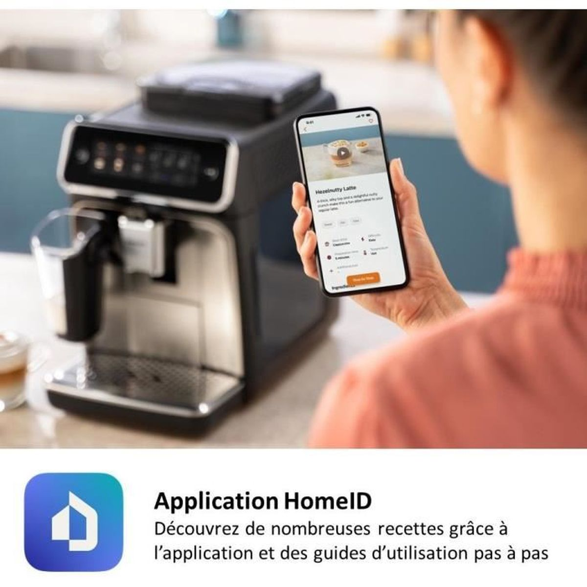 Eine Person hält ein Smartphone mit Kaffee-Rezept vor einer Kaffeemaschine.
