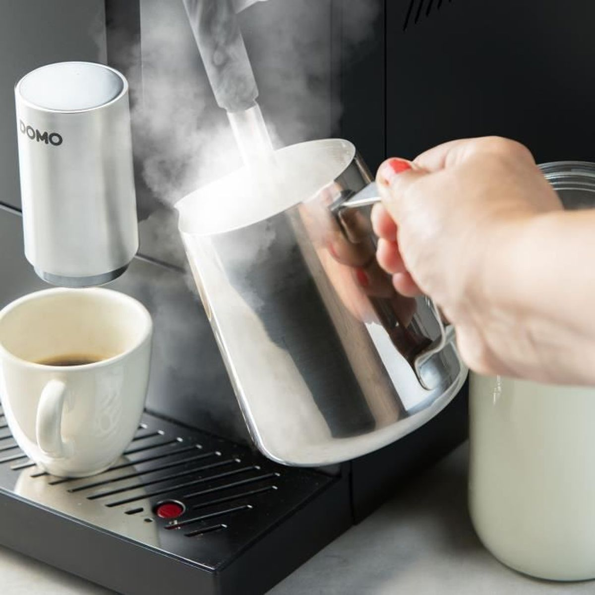 Il vapore viene versato in una lattiera sopra una macchina da caffè.