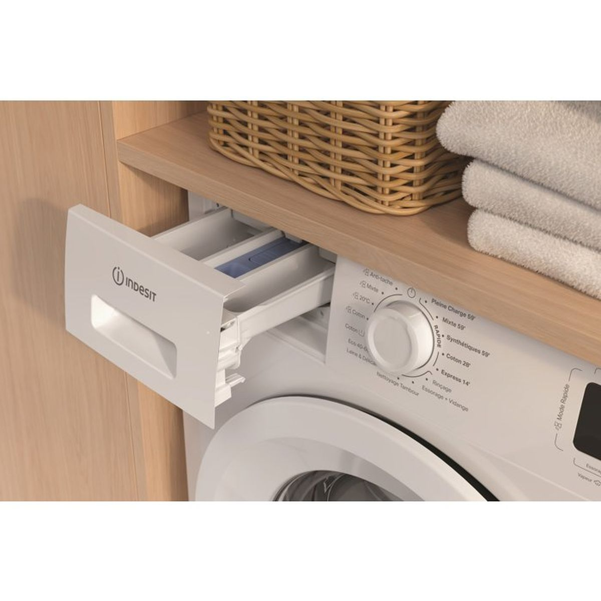 Ausgezogene Waschmittelschublade einer Indesit-Waschmaschine mit Handtüchern und Wäschekorb.