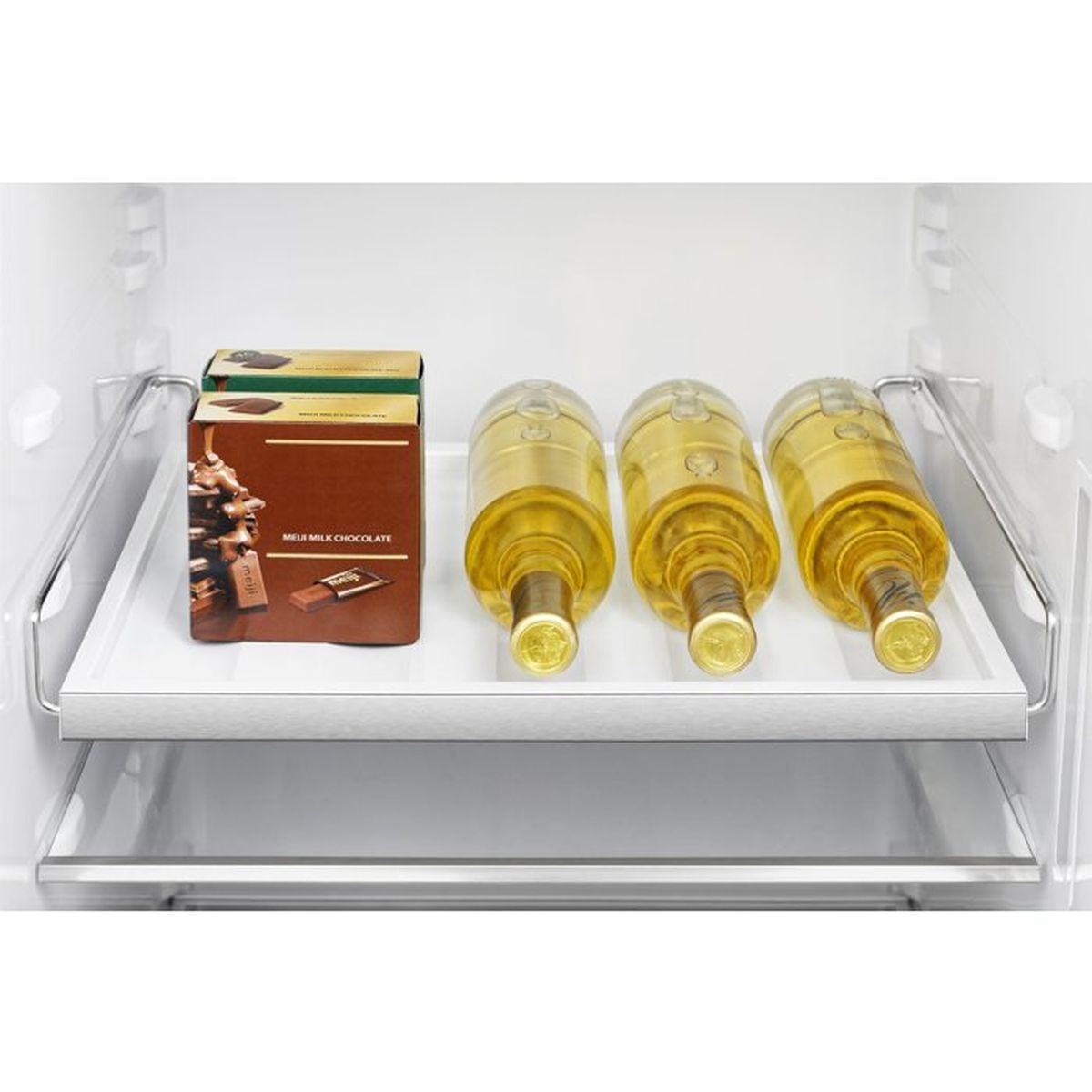 Drei Weinflaschen und eine Schachtel Meiji-Milchschokolade auf einem weißen Regal im Kühlschrank.