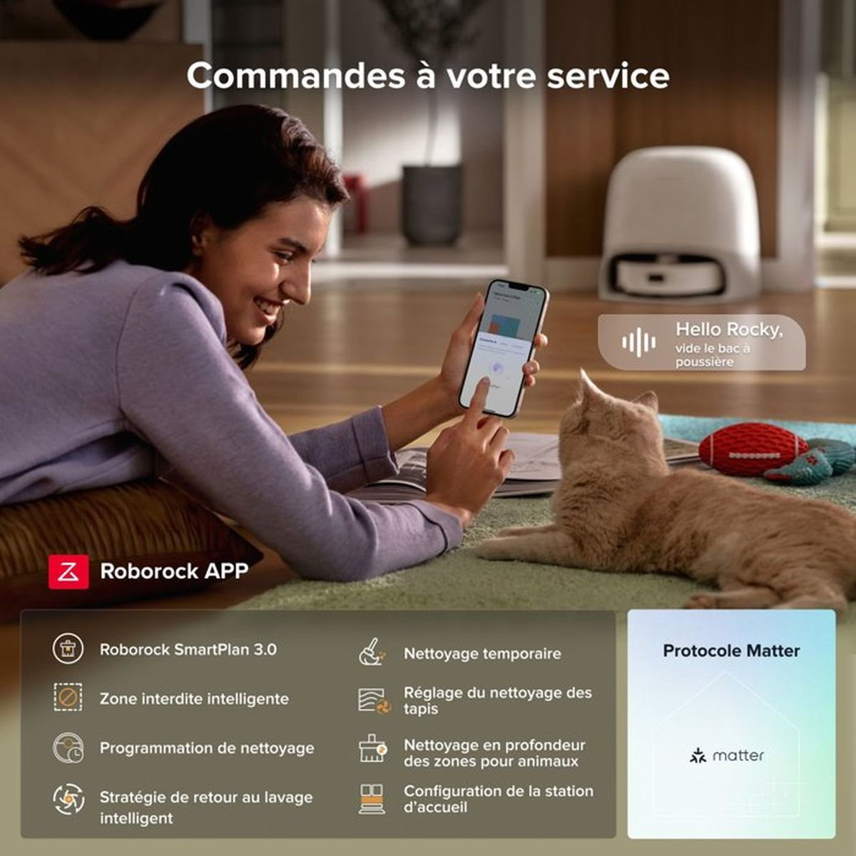 Frau bedient Roboterstaubsauger-App mit Katze und Roboter im Hintergrund.